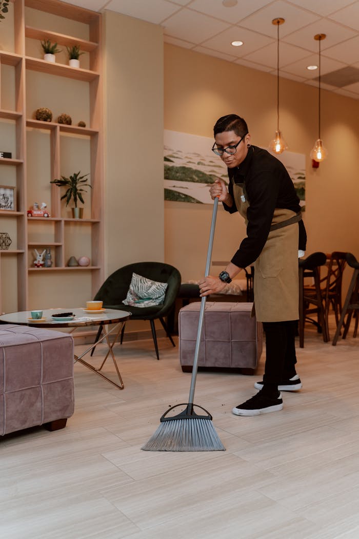 Waiter cleaning modern cafe interior, bringing organization and cleanliness to the space.